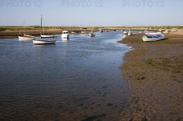 Boats in a tidal creek at Burnham Overy Staithe, north Norfolk coast, England, United Kingdom,