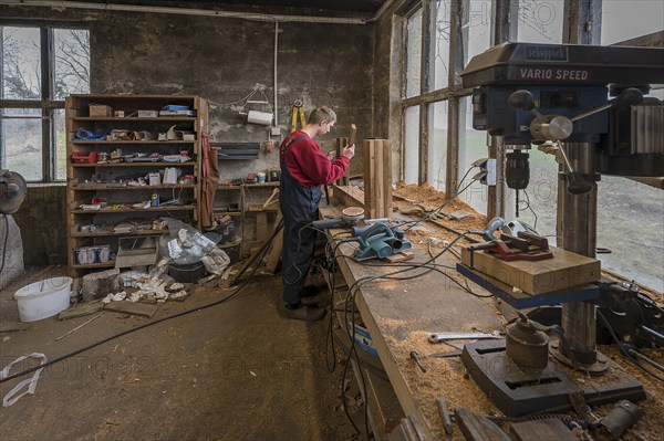 Young man builds a table in his workshop, Mecklenburg-Vorpommern, Germany, Europe