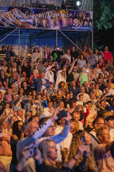 Crowd at night concert in front of stage with welcome banner, Klostersommer, Calw Hirsau, Black