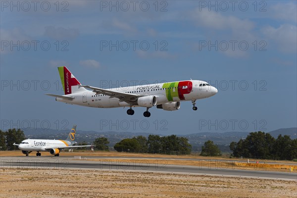 Two aeroplanes, Portugal on approach, Condor on the runway, sunny day with slightly cloudy sky,