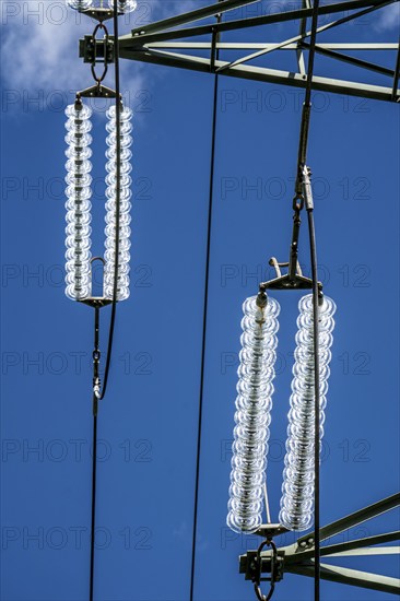 Insulators made of glass on a high-voltage line, they hang on the pylons as a suspension device