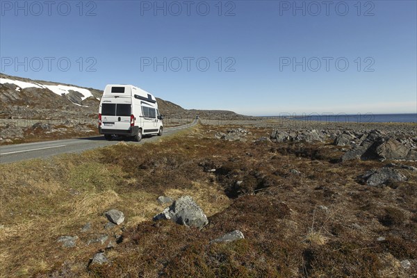 Campervan/caravan on a lonely coastal road through the tundra near Hamningberg on the Barents Sea,