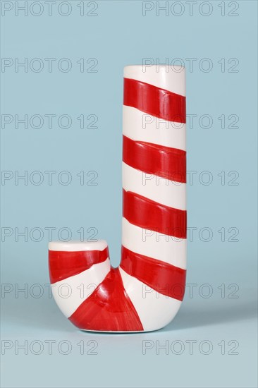 Red and white striped Christmas candy cane on blue background