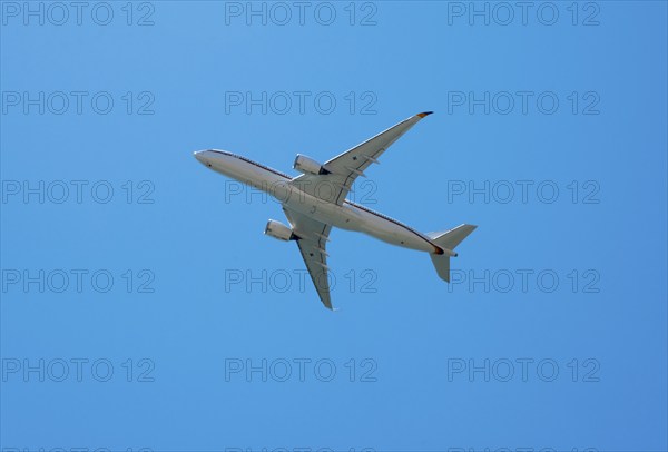 A large aircraft flies through a clear blue sky, Airbus A350 with the registration number 10 plus