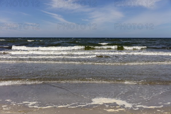 Foamy waves crash onto the coast in sunny weather and blue skies, Rügen, Hiddensee