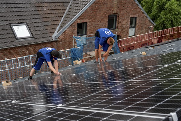 Installation of solar modules on the roof of a barn on a farm, over 240 photovoltaic modules are