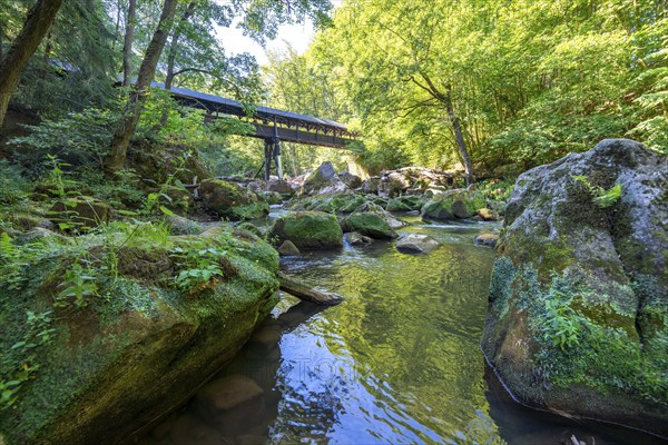 The Irrel Waterfalls, rapids in the lower reaches of the Prüm, covered wooden bridge for hikers,