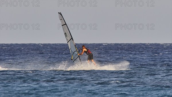 A windsurfer navigates with a big sail over the blue water, windsurfer, Meltemi windsurfing spot,