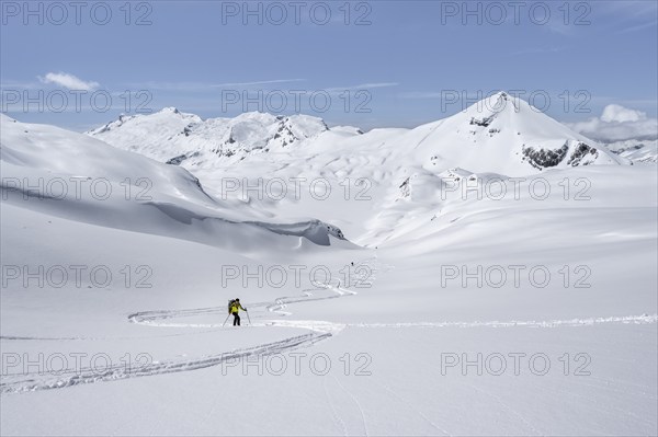 Lone ski tourer in mountain landscape with snow, summit Mittaghorn and Wildhorn, ascent to