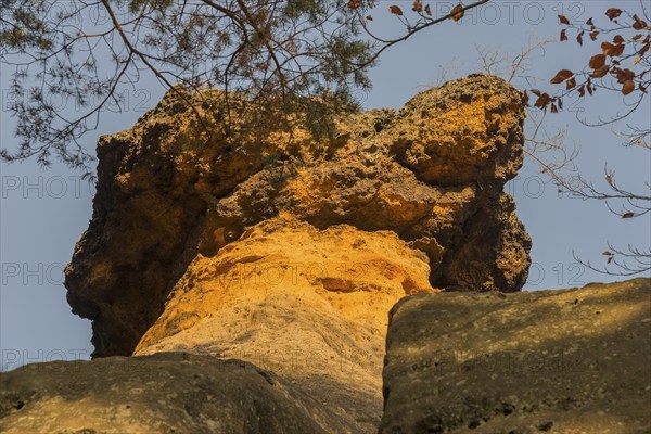 Close-up of a bright orange rock formation with trees and blue sky, Kokorinske poklicky rock