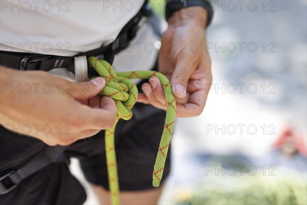 Subject: A climber ties himself / herself into a rope to climb on the rock, Morsbach, 09.07.2024
