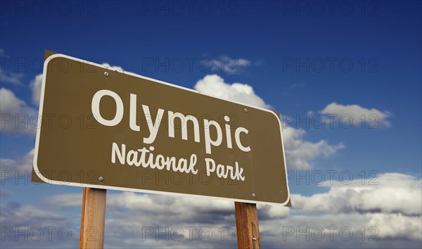 Olympic national park (washington) road sign against blue sky and clouds