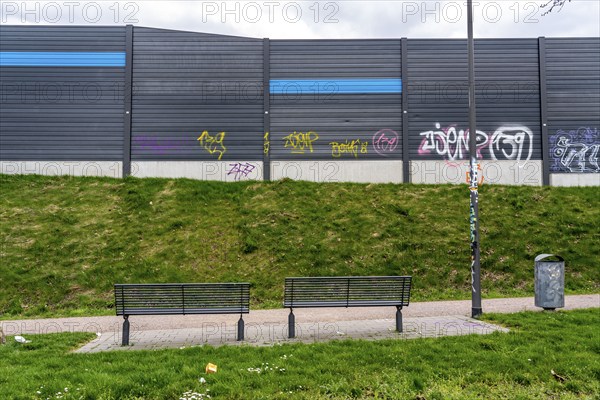 Green space, in Duisburg-Beck, park bench with view of the noise barrier of the A42 motorway,