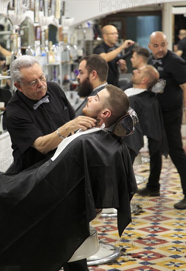Traditional barber shop customer being shaved, El Kinze de Cuchilleros, Madrid city centre, Spain,