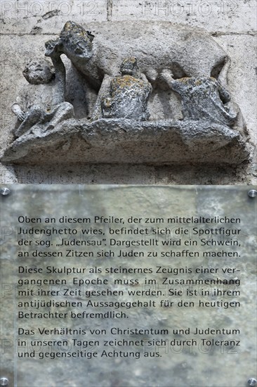 Medieval mocking figure of the so-called Judensau at St Peter's Cathedral, below information sign