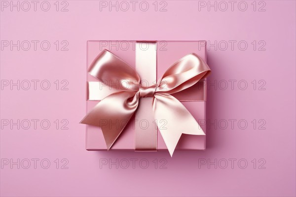 Top view of pink gift box with silk bow on pink studio background. KI generiert, generiert AI