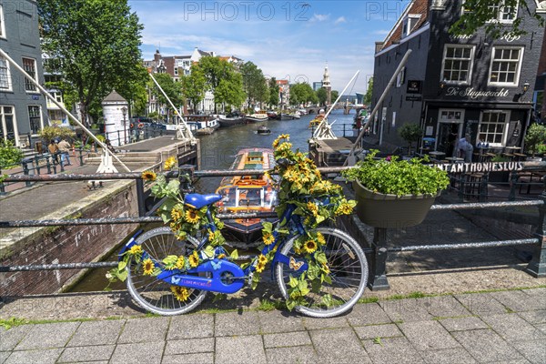 Sint Antoniesluis, on the Oudeschans canal, bicycle decorated with sunflowers, canal cruise boat,