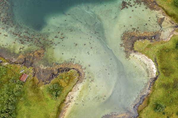 Aerial view of a bay at the Raftsund, single hut with boat, fjord between Lofoten and Vesteralen,