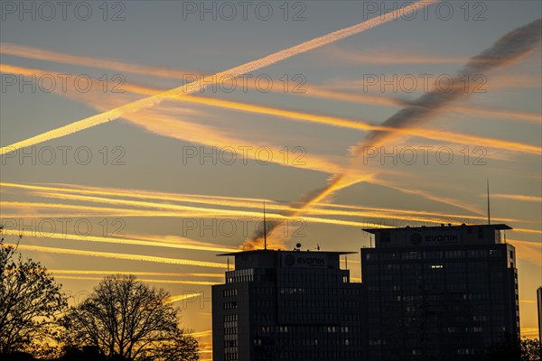 Condensation trails from aircraft flying at high altitude, evening sky, after sunset