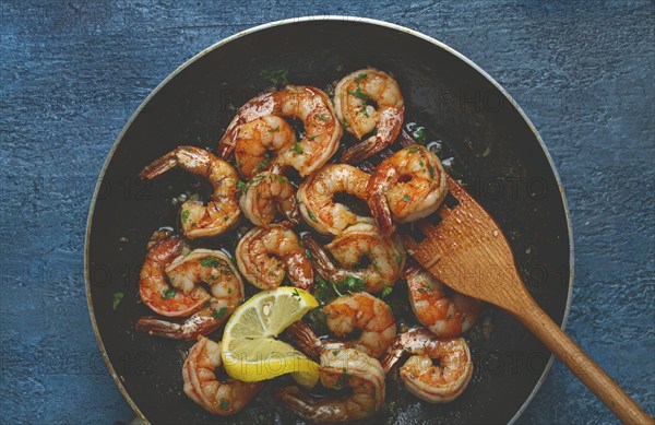 Fried tiger prawns, jumbo, in garlic sauce, in butter, with herbs, in a frying pan, homemade, no