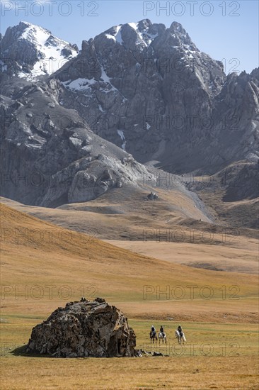 Rider in front of mountain landscape with yellow meadows, mountain peak, Keltan Mountains, Sary