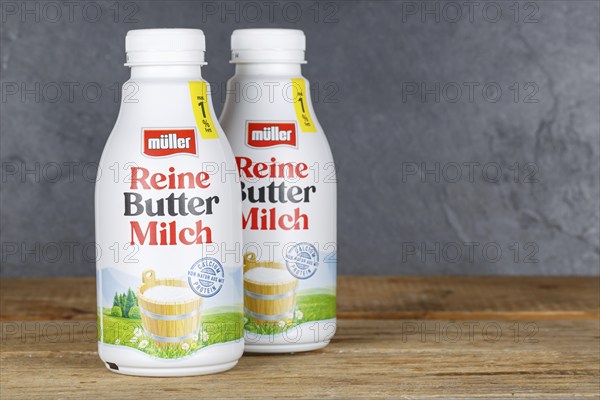 Pure buttermilk from the company Theo Müller on wooden board with text free space Copyspace