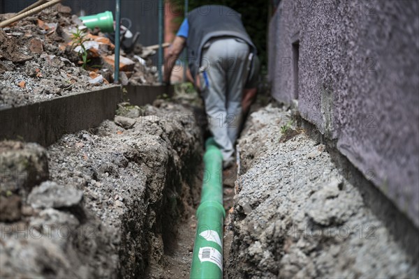 Construction worker, newly laid green sewage pipe, trench, Stuttgart, Baden-Württemberg