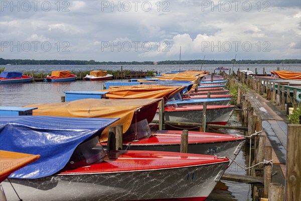 Colourful boats anchored at a wooden jetty, under a cloudy sky, Bad Zwischenahn, Zwischenahner
