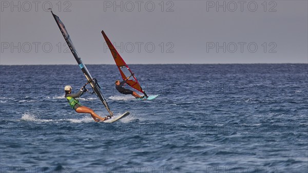 Two people windsurfing on the open sea under a clear sky, windsurfer, Meltemi windsurfing spot,