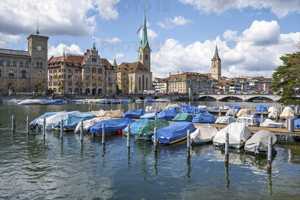 Boats at the jetty in the river Limmat, towers of Fraumünster and St Peter, Old Town, Zurich,