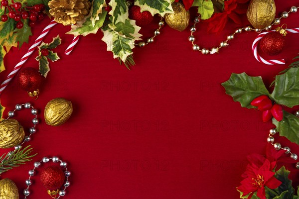 Christmas decoration frame with gold and red elements on a red background, copy room