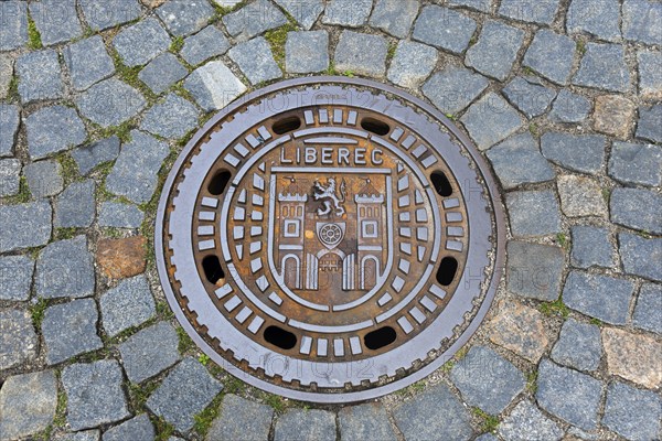 Manhole cover with Liberec city coat of arms, surrounded by cobblestones, manhole cover, Liberec,