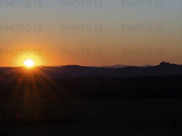 Sunset over the Kellerwald national park in autumn, with the town of Waldeck church and surrounding