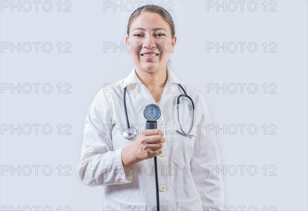 Young female doctor holding tensiometer on isolated background. Smiling female doctor showing blood