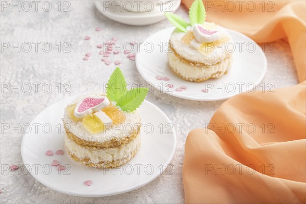 Decorated cake with milk and coconut cream with cup of coffee on a gray concrete background and