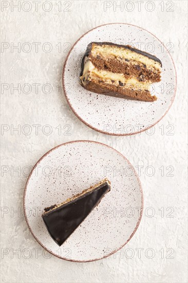 Chocolate biscuit cake with caramel cream and walnuts, on gray concrete background. top view, flat