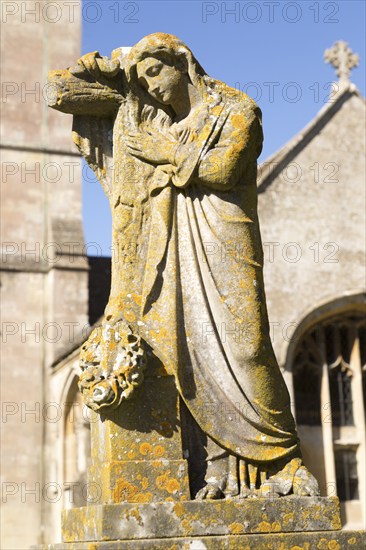 Statue on grave in graveyard of Church of Saint Bartholomew, Corsham, Wiltshire, England, UK