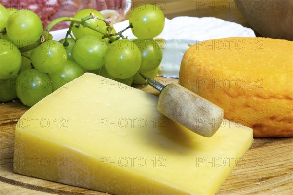 Cheese platter with various types of soft cheese and grapes