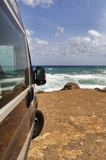 Campervan by the sea, motorhome parked on the rocky coast, coastline near La Isleta del Moro,