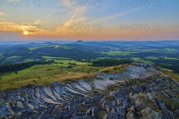 Panorama of a hilly landscape at sunset, showing fields and a cloudy sky, Abtsroder Kuppe,