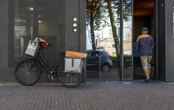 Dutch Post deliverer, with bicycle, in Rotterdam, Netherlands