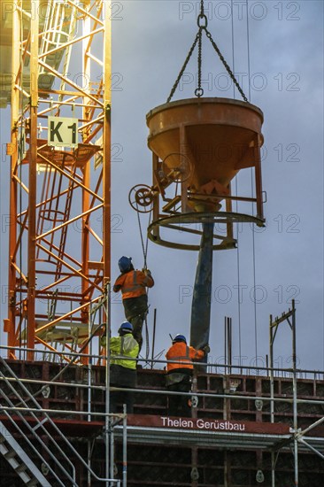 Concrete work, at dusk, on a large construction site building a residential and commercial complex,
