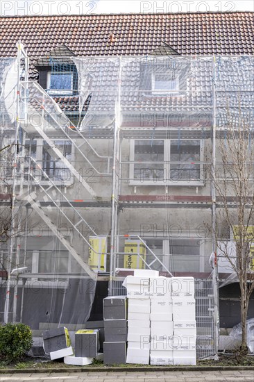 Energetic refurbishment of residential buildings, older apartment building is scaffolded, gets