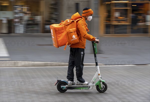 Delivery service Lieferando.de, delivery courier with e-scooter in the city centre, Rathenaustraße,