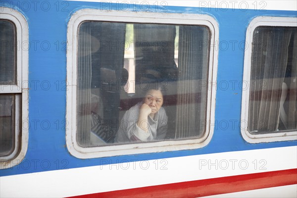 Vietnamese woman looking out of a train window, Hanoi, Vietnam, Asia