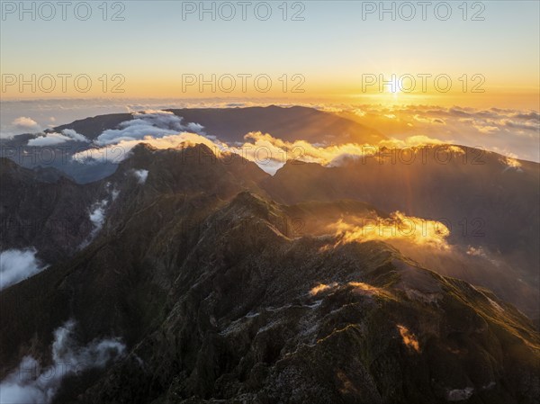 Aerial drone view of mountains over clouds near Pico Ruivo on sunset. Madeira island, Portugal,