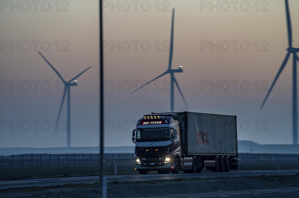 Lorry on the road to Euromax Terminal Rotterdam, ENECO wind farm on the dike around the port of
