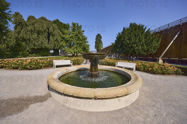 Fountain with benches, graduation tower and trees in the rose garden park in Bad Salzuflen, Lippe