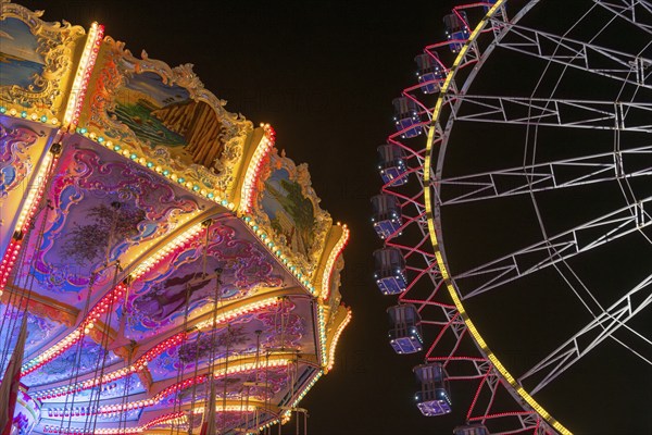 A funfair at night with illuminated chain carousel and Ferris wheel, Europa Rad, rides, wave