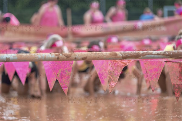 Group of participants in a muddy outdoor obstacle course